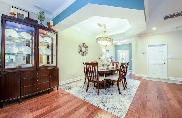 6303 Vista Verde Dr E, Gulfport, FL 33707 - dining space featuring visible vents, ornamental molding, baseboards, and wood finished floors