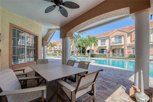 6303 Vista Verde Dr E, Gulfport, FL 33707 - view of patio featuring a community pool, a ceiling fan, outdoor dining space, and fence