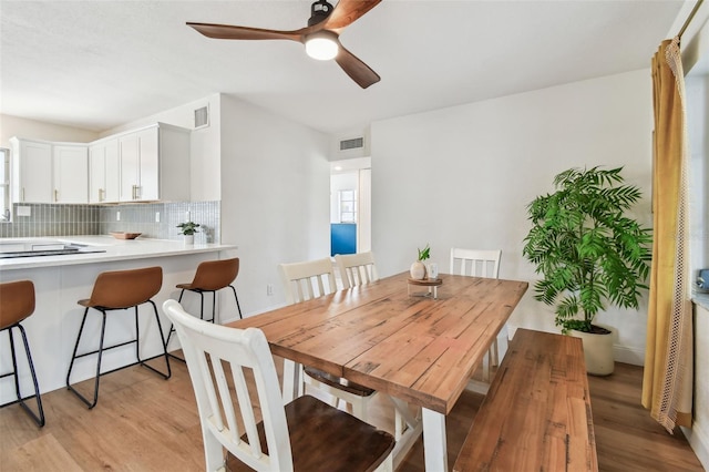 dining space with light wood-style flooring and a ceiling fan