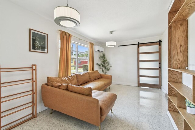 living area with an AC wall unit, a barn door, speckle patterned floor, and baseboards