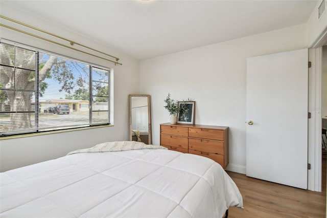 bedroom with wood finished floors and baseboards