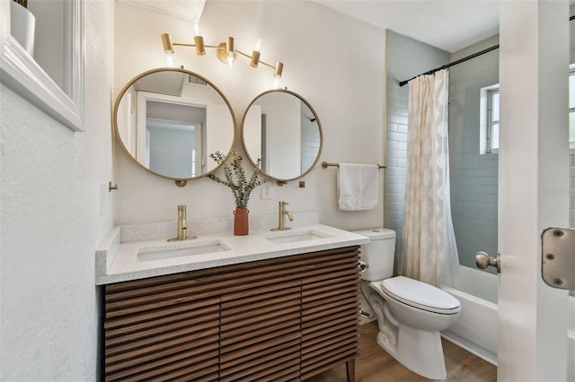 full bathroom featuring toilet, wood finished floors, double vanity, and shower / tub combo with curtain