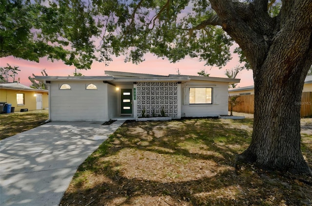 view of front of property with fence and concrete driveway