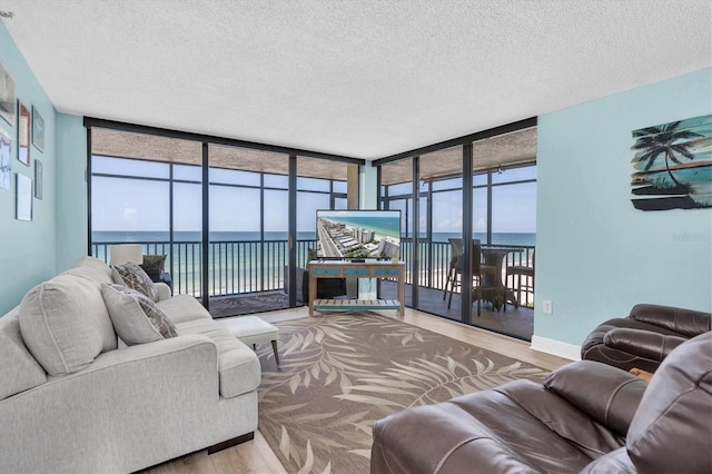 15400 Gulf Blvd Unit 202, Madeira Beach, FL 33708 - living room featuring plenty of natural light, floor to ceiling windows, a textured ceiling, wood finished floors, and baseboards