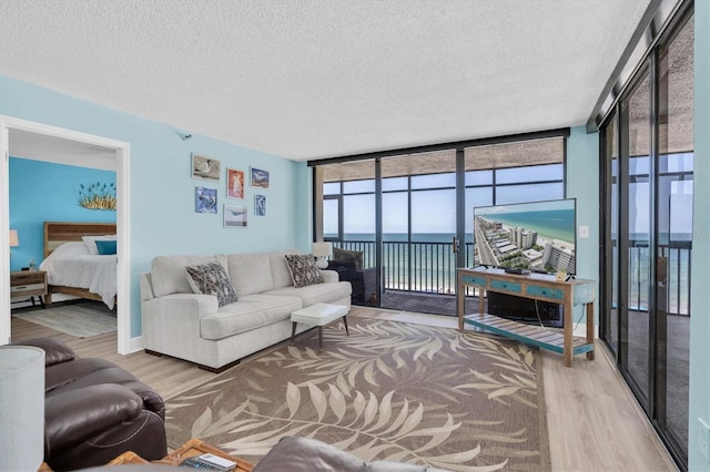 15400 Gulf Blvd Unit 202, Madeira Beach, FL 33708 - living area featuring a textured ceiling, expansive windows, and wood finished floors