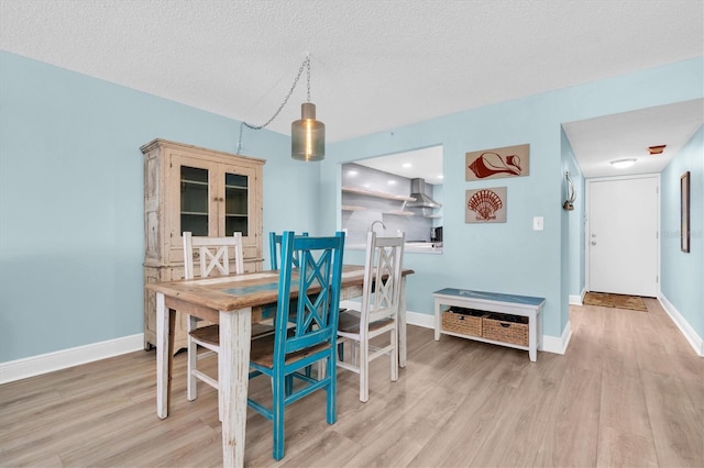15400 Gulf Blvd Unit 202, Madeira Beach, FL 33708 - dining area with baseboards, a textured ceiling, and light wood-style flooring
