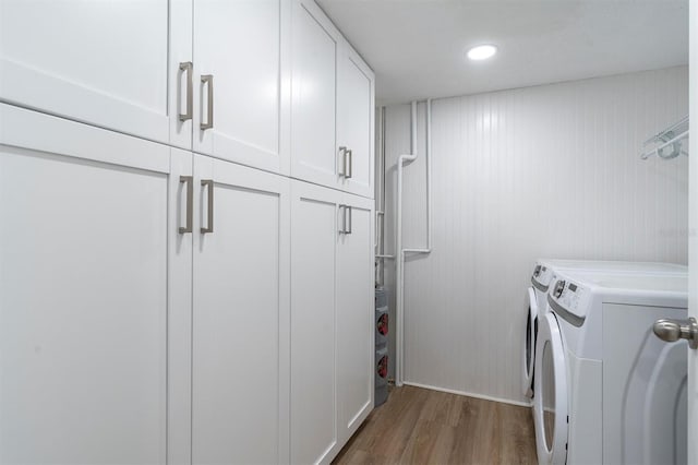 15400 Gulf Blvd Unit 202, Madeira Beach, FL 33708 - laundry area featuring recessed lighting, cabinet space, independent washer and dryer, and wood finished floors