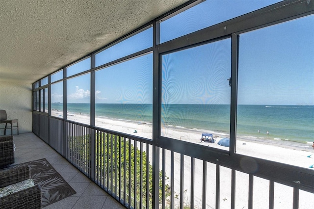 15400 Gulf Blvd Unit 202, Madeira Beach, FL 33708 - unfurnished sunroom featuring a beach view, a water view, and a wealth of natural light