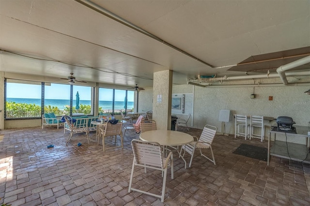 15400 Gulf Blvd Unit 202, Madeira Beach, FL 33708 - dining space featuring a water view, a ceiling fan, a wealth of natural light, and brick floor