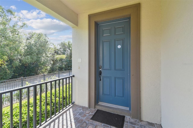 doorway to property featuring a balcony and stucco siding