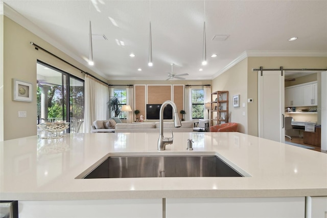 kitchen with crown molding, a ceiling fan, open floor plan, recessed lighting, and a sink
