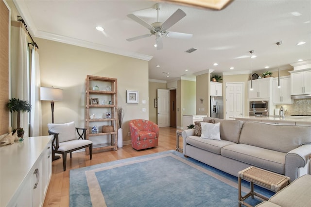 living area with light wood-style floors, ornamental molding, recessed lighting, and visible vents