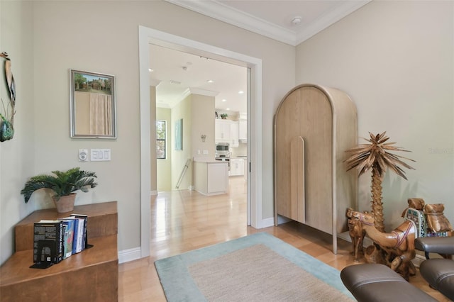 interior space featuring baseboards, ornamental molding, and light wood-type flooring