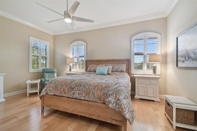 bedroom with crown molding, a ceiling fan, light wood-style flooring, and baseboards
