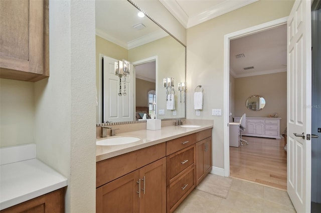 ensuite bathroom with a sink, double vanity, ensuite bathroom, visible vents, and ornamental molding