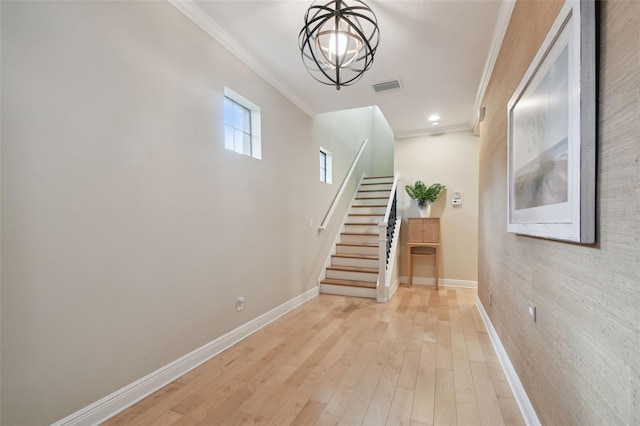hall with baseboards, ornamental molding, and stairway