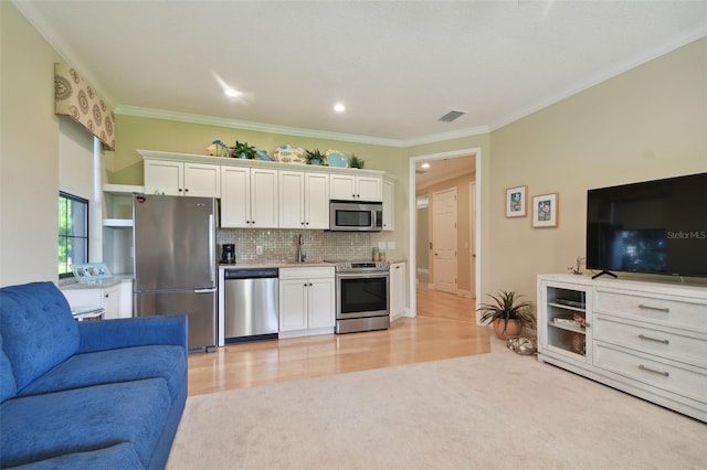 kitchen with white cabinets, stainless steel appliances, open floor plan, backsplash, and visible vents