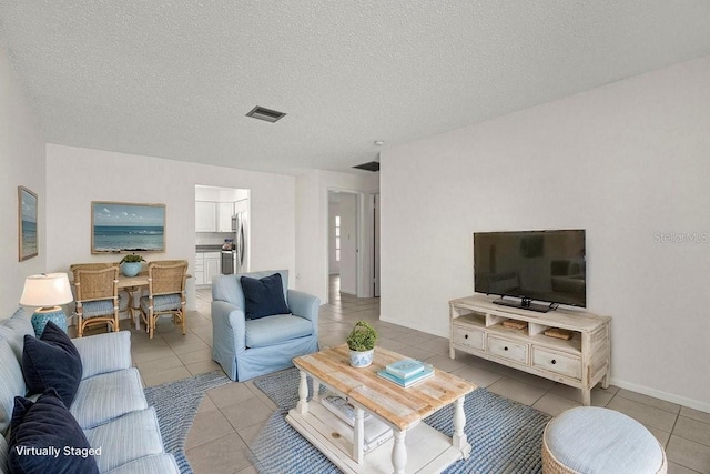living room featuring light tile patterned floors and a textured ceiling