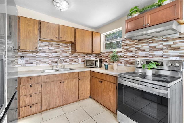 8184 Rose Ter, Seminole, FL 33777 - kitchen with under cabinet range hood, stainless steel appliances, light countertops, a sink, and decorative backsplash