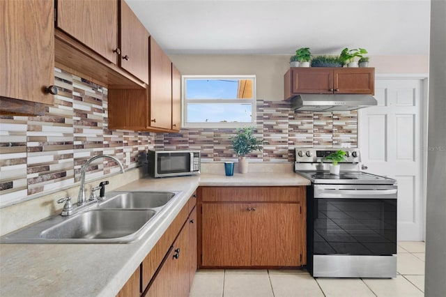 8184 Rose Ter, Seminole, FL 33777 - kitchen featuring under cabinet range hood, light countertops, a sink, decorative backsplash, and appliances with stainless steel finishes