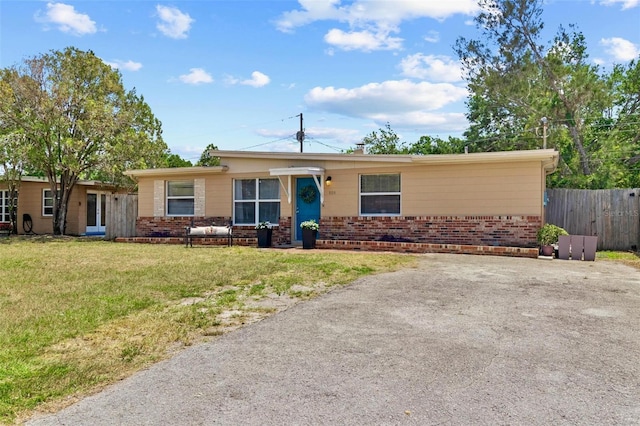 8184 Rose Ter, Seminole, FL 33777 - view of front of home with brick siding, a front yard, and fence