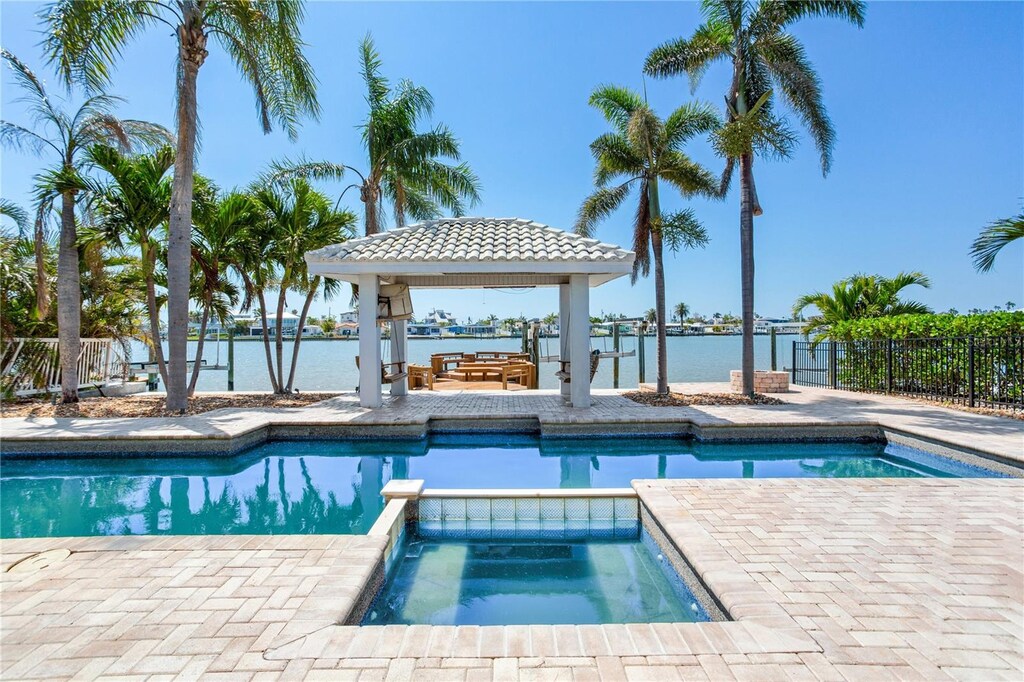 16353 Redington Dr, Redington Beach, FL 33708 - view of swimming pool featuring fence, a water view, a pool with connected hot tub, and a gazebo