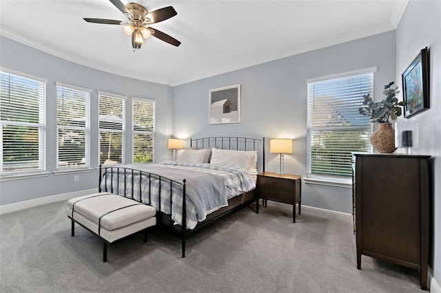 carpeted bedroom featuring baseboards, crown molding, multiple windows, and a ceiling fan