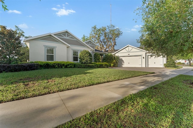 view of front of house with driveway, a front yard, stucco siding, and an attached garage