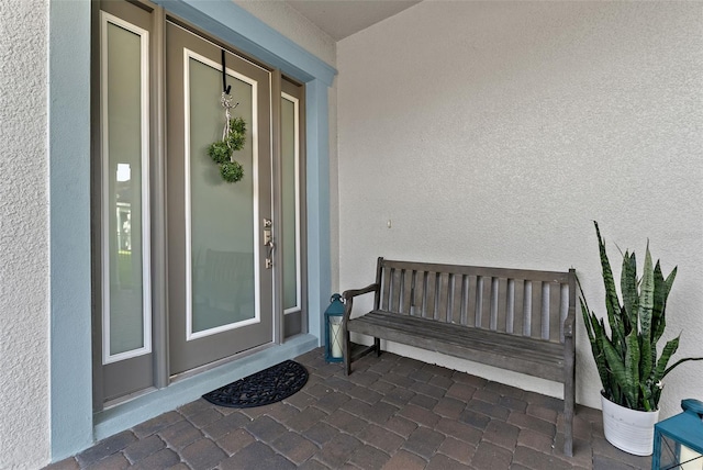 doorway to property featuring stucco siding