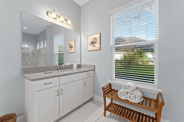 full bath featuring baseboards, vanity, and a shower