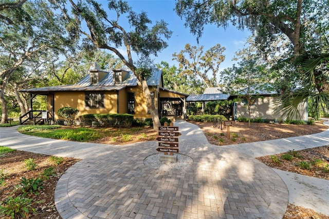 view of front of home featuring metal roof, a standing seam roof, and a chimney