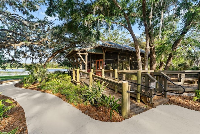 view of side of home featuring a sunroom and metal roof