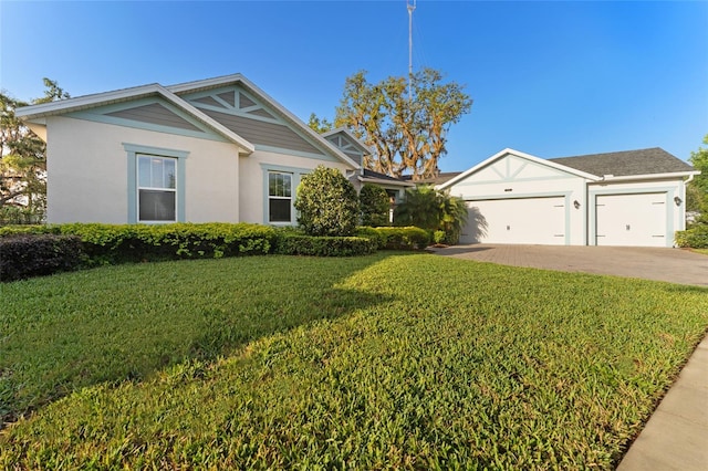 view of front of property with a front yard, an attached garage, driveway, and stucco siding