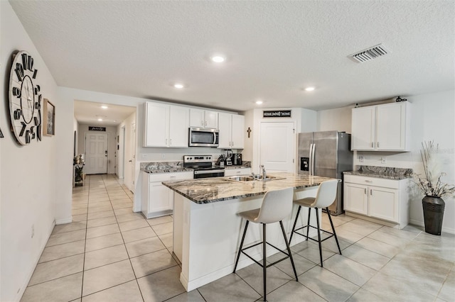 10463 Baylor Dr, Spring Hill, FL 34608 - kitchen featuring stainless steel appliances, a sink, a textured ceiling, visible vents, and stone countertops