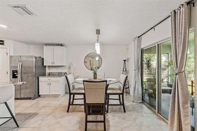 10463 Baylor Dr, Spring Hill, FL 34608 - dining space featuring a textured ceiling, visible vents, and light tile patterned floors