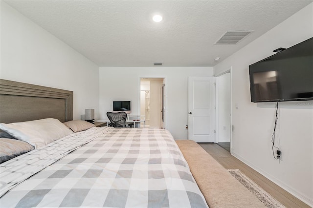 10463 Baylor Dr, Spring Hill, FL 34608 - bedroom with a textured ceiling, wood finished floors, visible vents, and baseboards