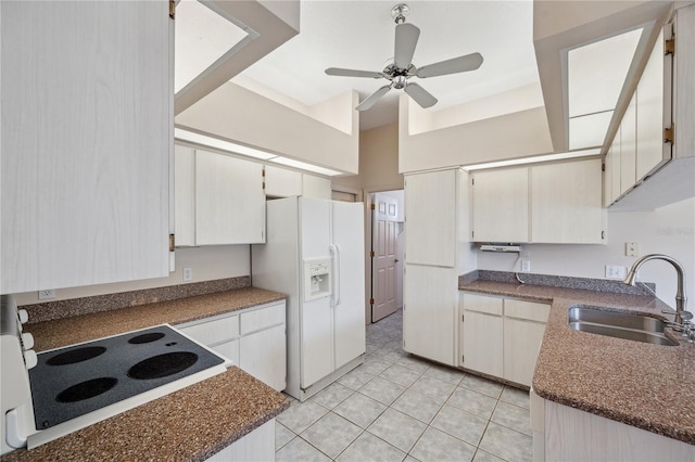 kitchen featuring a ceiling fan, white refrigerator with ice dispenser, stove, a sink, and light tile patterned flooring