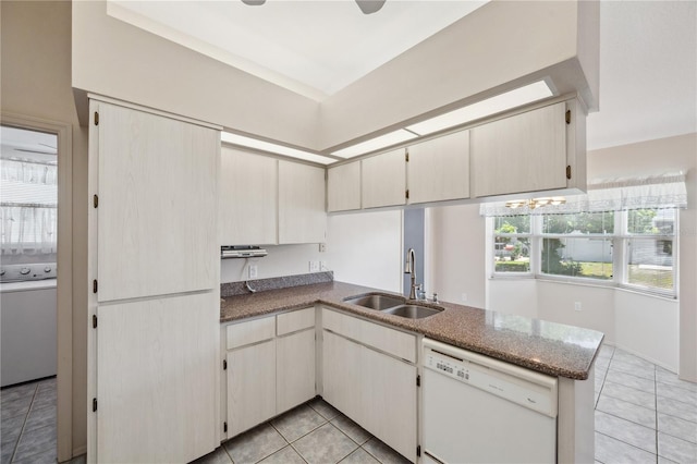 kitchen with a sink, light tile patterned floors, dishwasher, and a peninsula