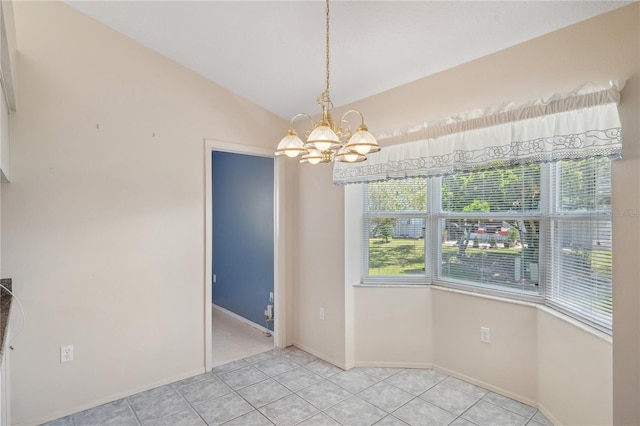 unfurnished dining area with an inviting chandelier, plenty of natural light, light tile patterned floors, and vaulted ceiling