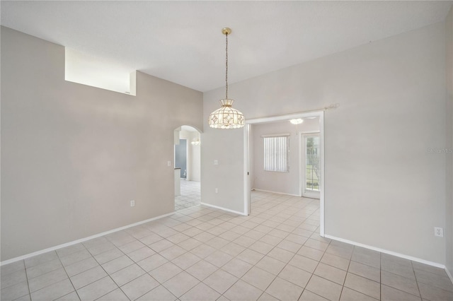 empty room featuring arched walkways, baseboards, a notable chandelier, and light tile patterned flooring