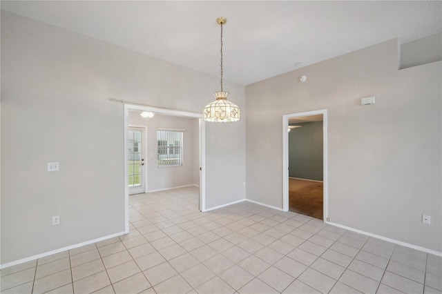 spare room with light tile patterned flooring, baseboards, and a notable chandelier