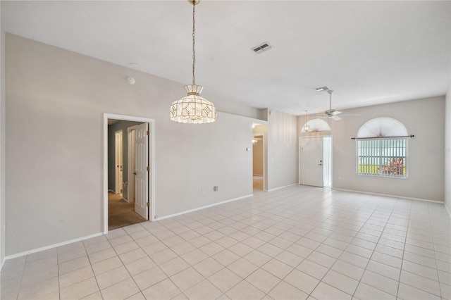 empty room with light tile patterned floors, ceiling fan, visible vents, and baseboards