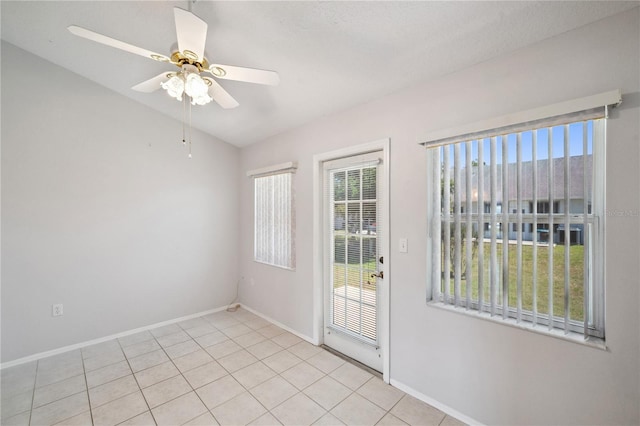 spare room with light tile patterned floors, baseboards, a ceiling fan, and lofted ceiling