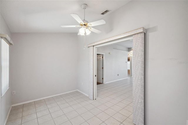 empty room with light tile patterned flooring, ceiling fan, visible vents, and baseboards