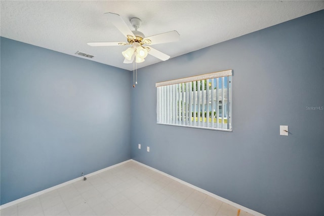 unfurnished room featuring a ceiling fan, baseboards, visible vents, and a textured ceiling