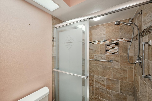 full bathroom with a shower stall and toilet
