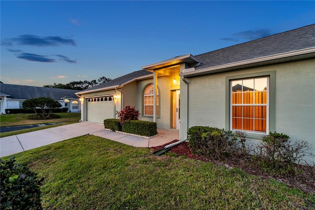 ranch-style house featuring roof with shingles, a front lawn, concrete driveway, an attached garage, and stucco siding