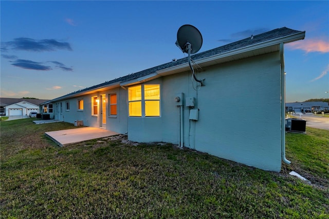 rear view of house featuring stucco siding, a yard, and a patio area