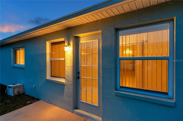 entrance to property featuring stucco siding
