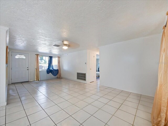 unfurnished living room with a ceiling fan, visible vents, and a textured ceiling